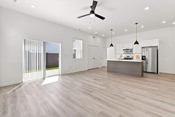 A modern kitchen with a wooden floor and white walls.