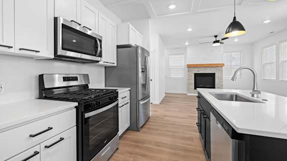 A modern kitchen with white cabinets and stainless steel appliances.at Alante Homes at Spring Run, Caldwell, ID