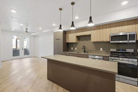 Modern kitchen with a large island and stainless steel appliances at Brickside Heights, Utah, 84106