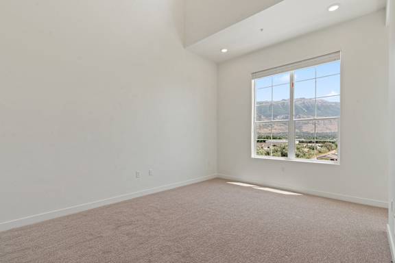 A large empty room with a window overlooking a mountainous landscape.