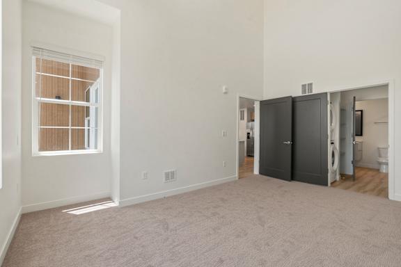 A room with a window and a washer and dryer in it.