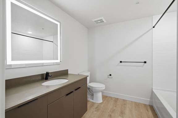White bathroom with a sink, toilet, and mirror1 at Brickside Heights, Millcreek, 84106