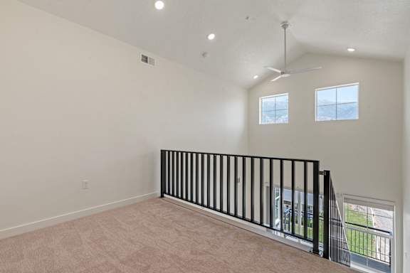 A room with a black railing and two windows.