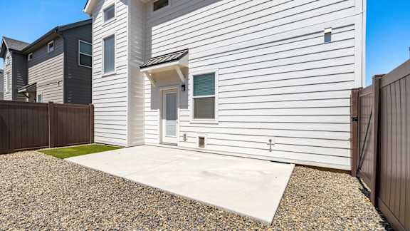 A modern house with a white front door and a small gravel driveway.at Alante Homes at Spring Run, Idaho