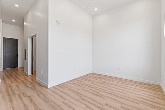 A room with wooden flooring and white walls.