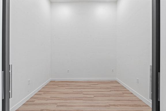 A room with wooden flooring and white walls.