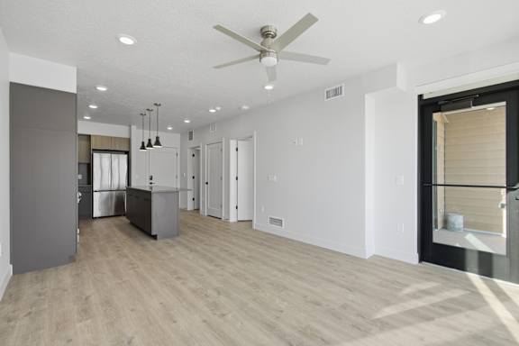 Spacious kitchen with a refrigerator, oven, and a ceiling fan at Brickside Heights, Millcreek, UT