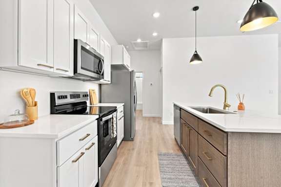 A modern kitchen with white cabinets and a black range hood.