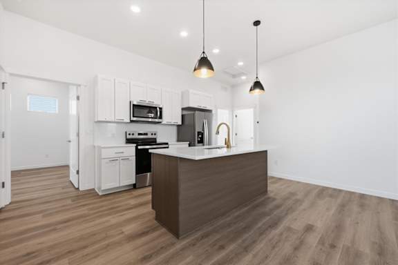 Kitchen with white closet and brown island at Alante Homes at Spring Run, Idaho, 83607
