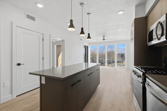 Modern kitchen with a large island and stove at Brickside Heights, Millcreek, UT, 84106