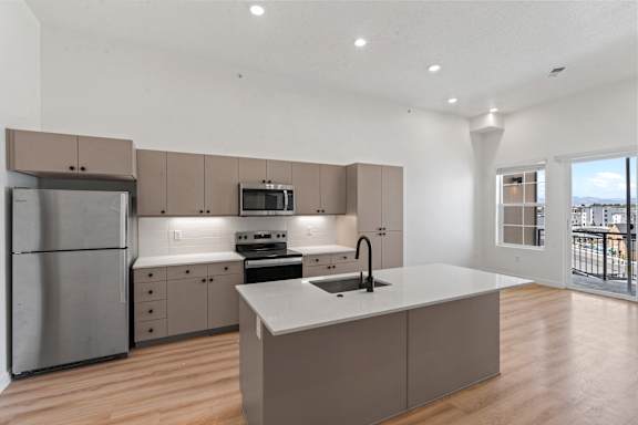 A modern kitchen with a large island and stainless steel appliances.
