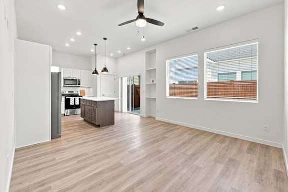 A spacious living room with a kitchen in the background.