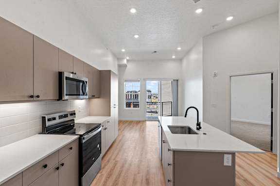 A modern kitchen with a long counter and a microwave above the oven.