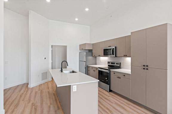A kitchen with a white counter top and beige cabinets.