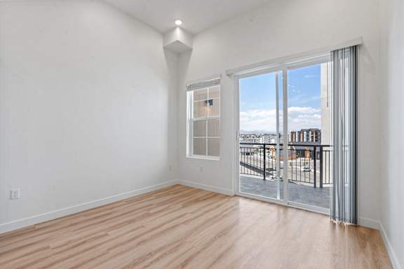 A room with a sliding glass door leading to a balcony.