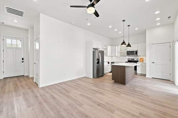 A spacious kitchen with a refrigerator, microwave, and oven.
