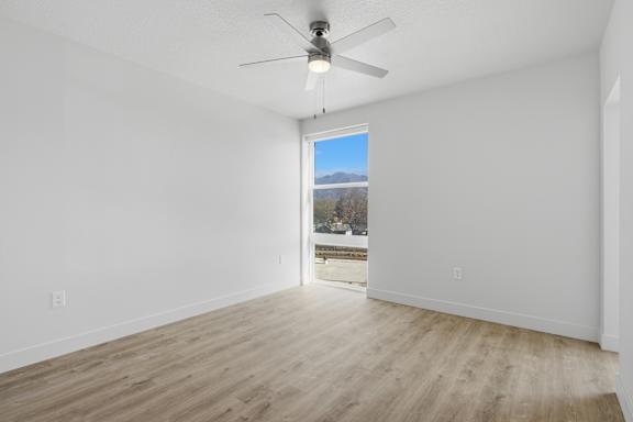 Large empty room with ceiling fan and wooden floor2 at Brickside Heights, Millcreek, UT, 84106