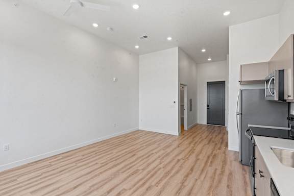 A kitchen area with a sink, stove, and refrigerator.