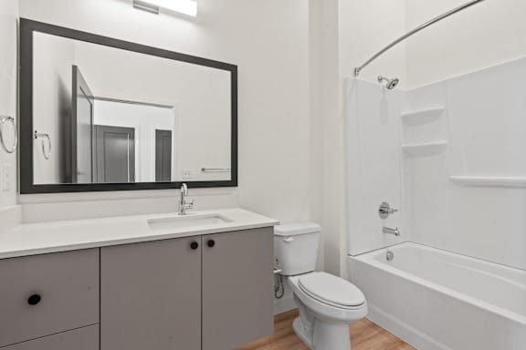 A white bathroom with a sink, toilet, and bathtub.