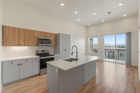 A modern kitchen with wooden cabinets and a large island.