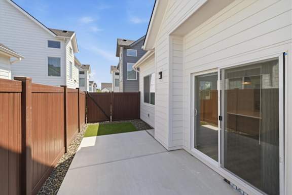 A white house with a brown fence and glass door.