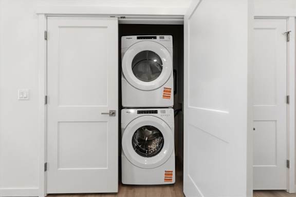 Front loading stacked washing machine and dryer in laundry room at Alante Homes at Spring Run, Caldwell, Idaho