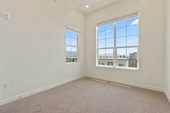 A large empty room with a window overlooking a cityscape.