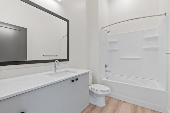 A white bathroom with a sink, toilet, and bathtub.