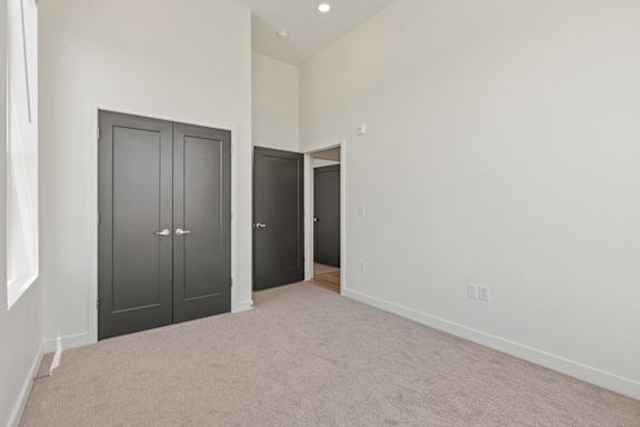 A room with two doors and a carpeted floor.