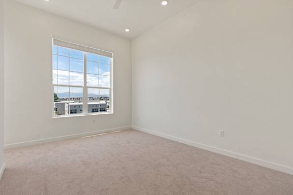 A large empty room with a window overlooking a cityscape.