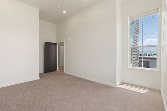 A large empty room with a door and a window.