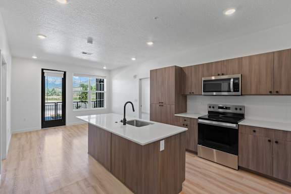 A modern kitchen with wooden cabinets and stainless steel appliances.