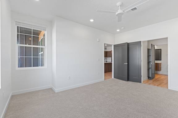 A room with a ceiling fan and a window.