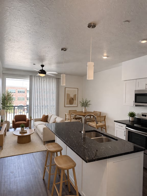 A modern kitchen with a black countertop and white cabinets.