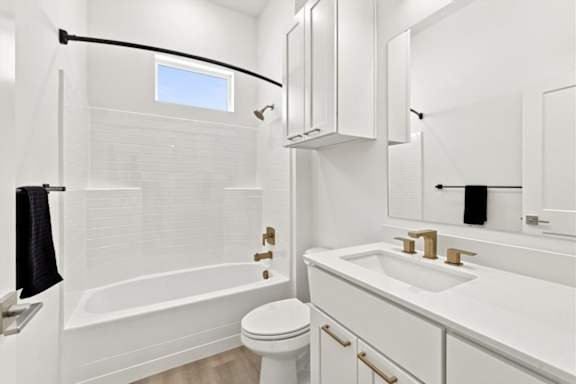 A white bathroom with a toilet, sink, and bathtub.