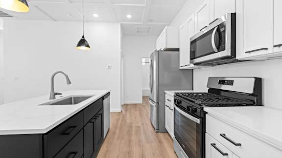 A modern kitchen with black and white appliances and cabinets.at Alante Homes at Spring Run, Caldwell, ID 83607