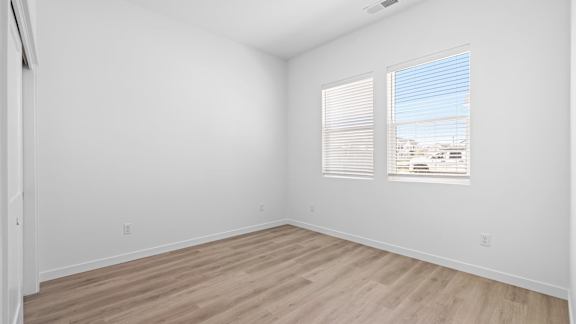 A room with wooden flooring and a window with blinds.at Alante Homes at Spring Run, Caldwell, ID 83607