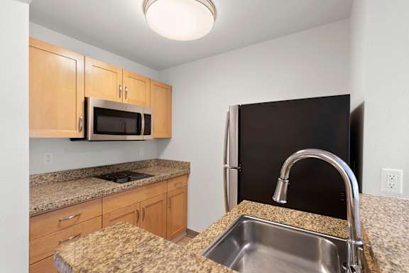 Kitchen with granite countertops and sink at AVIA on Pike Street, Washington, 98101