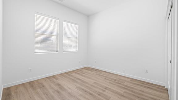 A room with wooden flooring and two windows with blinds.at Alante Homes at Spring Run, Idaho