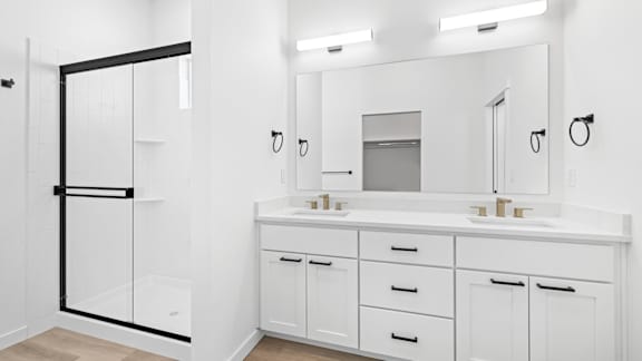A white bathroom with a sink, mirror, and cabinets.at Alante Homes at Spring Run, Caldwell, ID 83607
