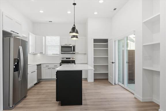 Modern Kitchen with black island and hanging lights at Alante Homes at Spring Run, Caldwell, Idaho