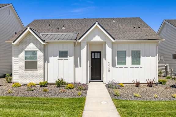 A white house with a black door and windows.