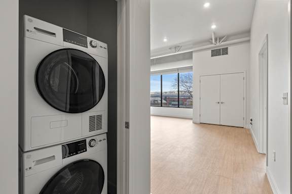 Modern front loading washing machine in laundry room at Brickside Heights, Millcreek, 84106