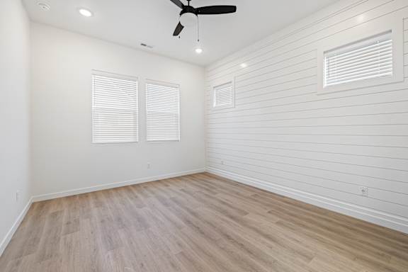 A room with a ceiling fan and two windows.at Alante Homes at Spring Run, Caldwell, ID