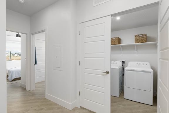 A white laundry room with a washer and dryer. at The Vue At Desert Color, St. George, Utah