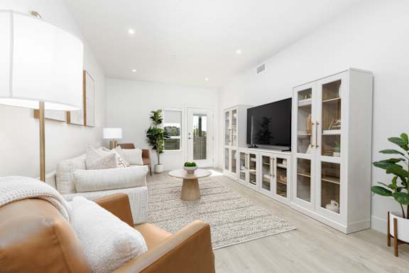A living room with a brown leather couch and a white sofa. at The Vue At Desert Color, St. George