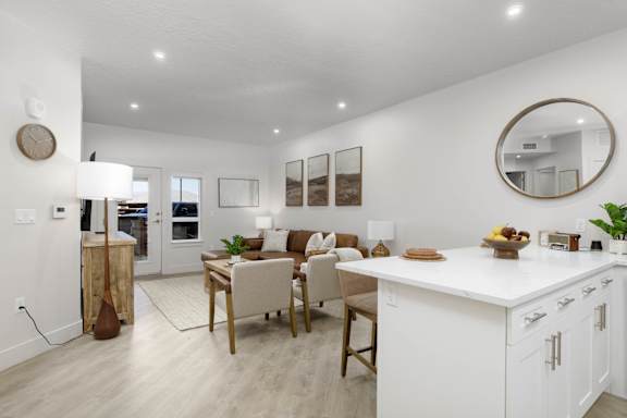 A modern kitchen with white cabinets and a wooden island. at The Vue At Desert Color, St. George, 84790