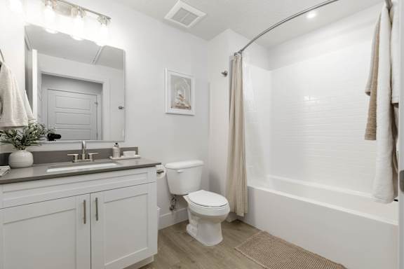 A white bathroom with a toilet, sink, and bathtub. at The Vue At Desert Color, St. George