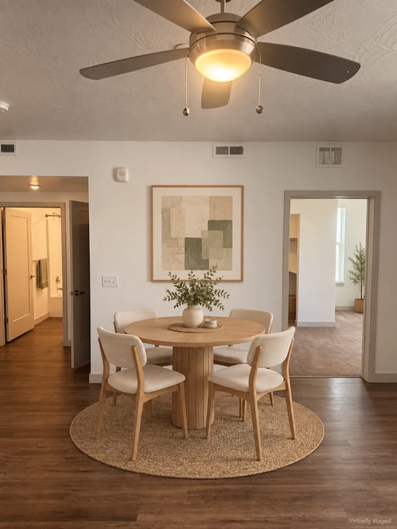 A dining room with a round table and chairs.