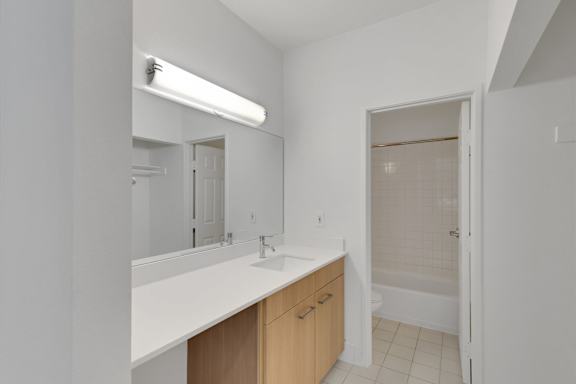 Bathroom with mirror and sink at AVIA Apartments On Alpha, Dallas, Texas